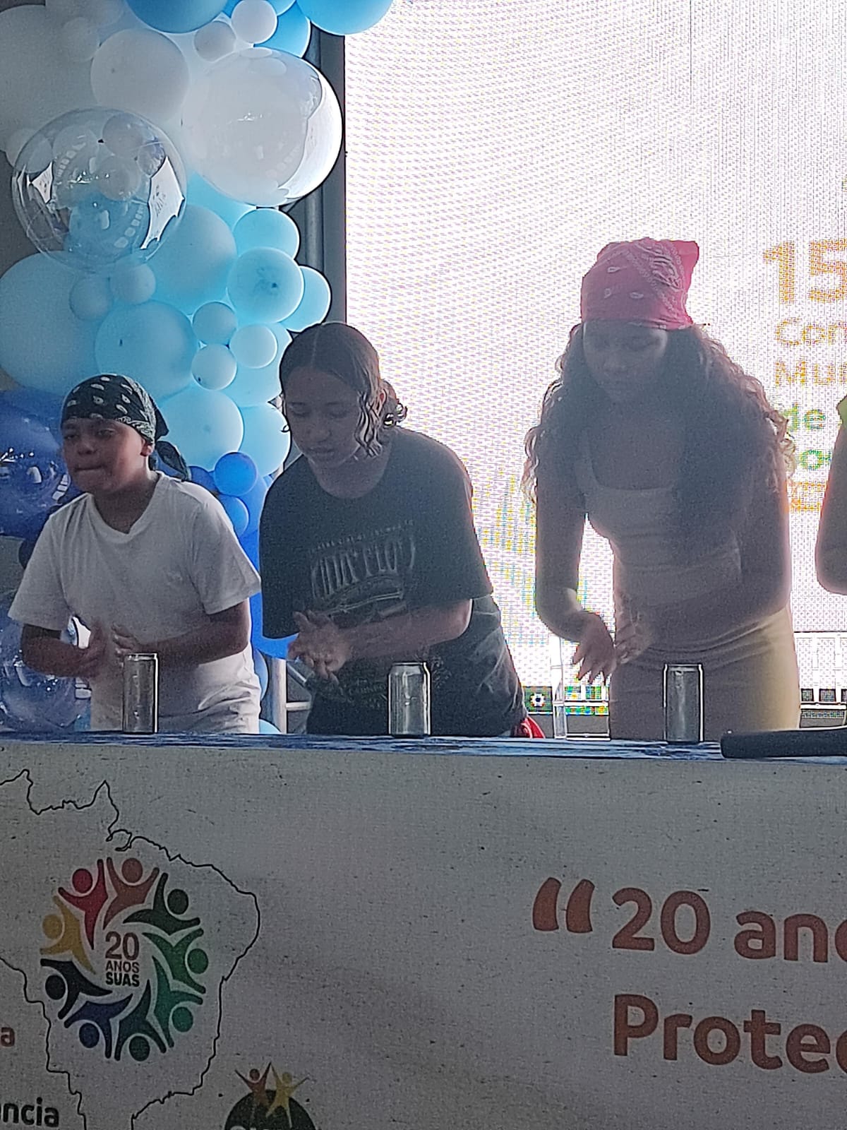 Detalhe da apresentação de percussão com latinhas realizada pelas jovens durante a conferência de assistência social